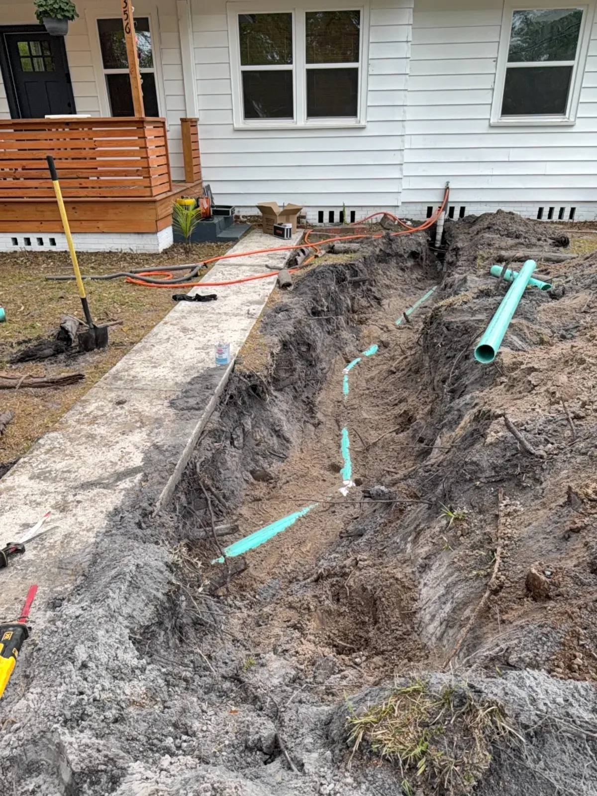Full trench from house to yard with new green PVC sewer line and cleanout risers installed