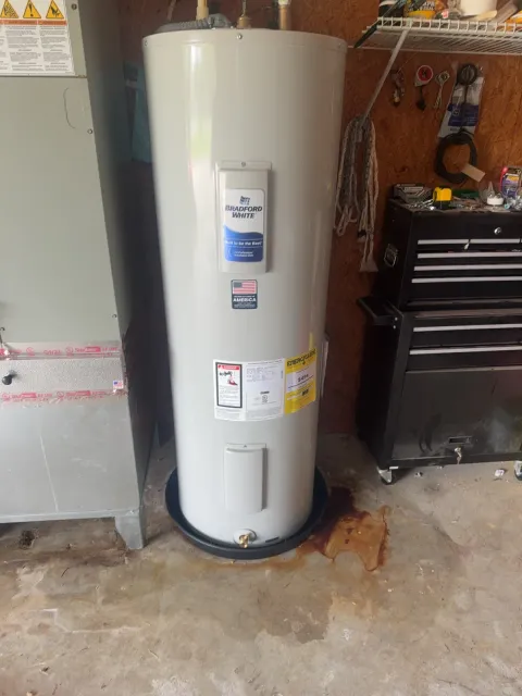 New Bradford White electric water heater in a drain pan in a garage, next to the air handler